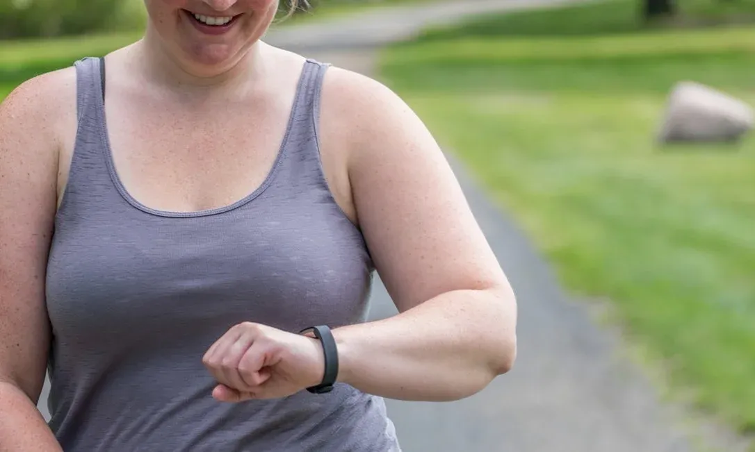 Woman Checking Fitness Tracker During Outdoor Exercise