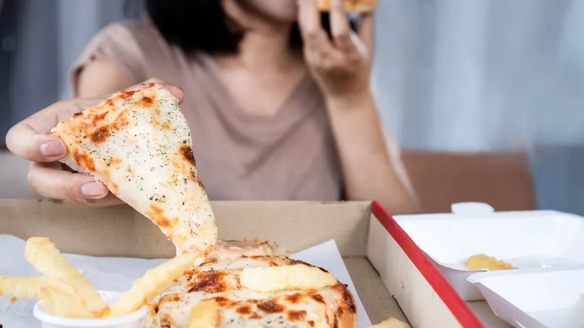 Person Eating Pizza And Fries