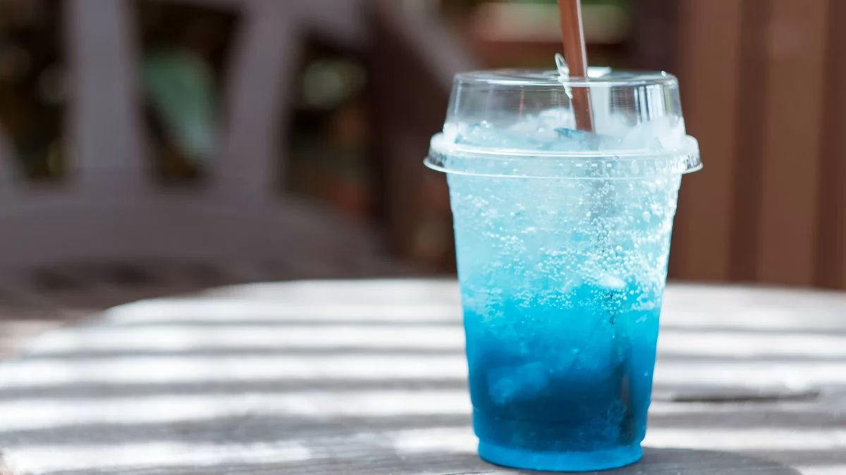 Blue Carbonated Drink In A Plastic Cup With A Straw